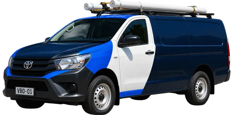 A licensed Balmain plumbing van loaded with pipe on the roof rack